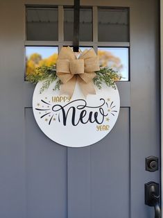 a new year's door hanger with a bow hanging on the front door