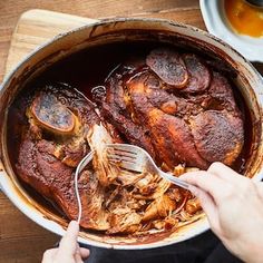 someone using a spatula to stir meat in a pot