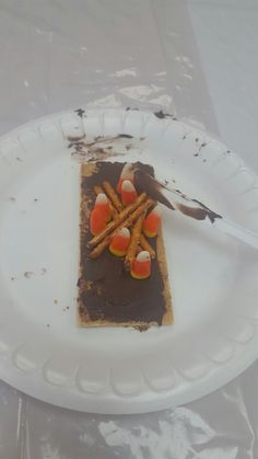 a piece of cake on a paper plate with chocolate and candy sticks sticking out of it