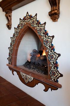 an ornate fireplace in the corner of a room with tile and woodwork on it