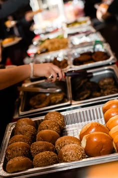 there are many different types of donuts on the buffet line at this restaurant,