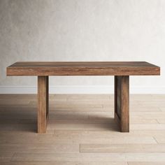 a wooden table sitting on top of a hard wood floor next to a white wall