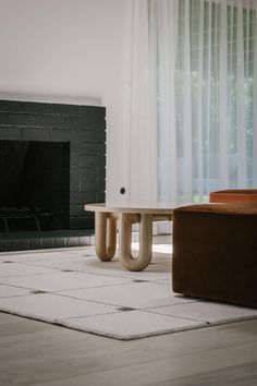 a living room with a fire place and two pieces of furniture in front of the fireplace