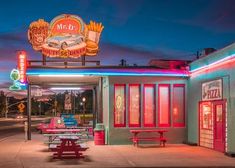 an old diner with neon lights on the outside