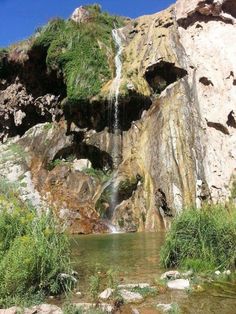 there is a small waterfall coming out of the rocks