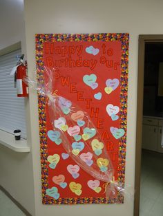 a happy birthday sign is hanging on the wall in front of a door with hearts