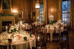 the dining room is set with white tablecloths, candles and centerpieces