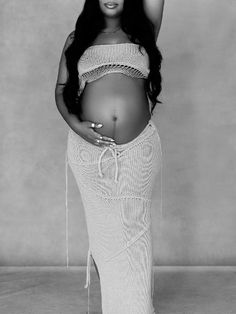 a pregnant woman with long black hair in a white dress