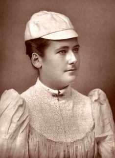 an old photo of a woman wearing a hat