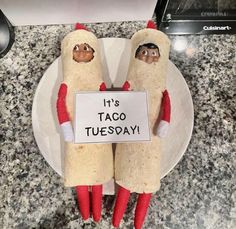 two hotdogs on a plate with a sign that says it's taco tuesday