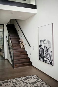 an image of a staircase with pictures on the wall and below it is a black and white photo