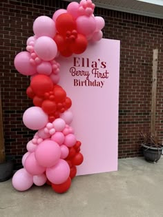 a pink and red balloon arch with balloons on it