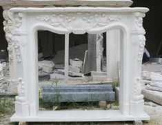 an old white fireplace in the middle of some rubble