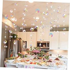 a kitchen filled with lots of bubbles hanging from the ceiling over a table covered in food