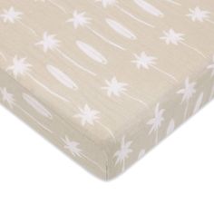 an image of a baby crib sheet with white flowers on it