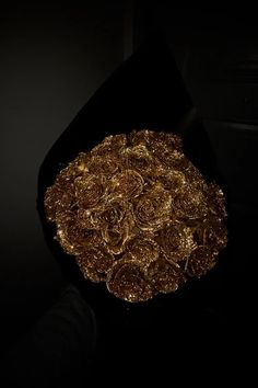 a bunch of gold coins sitting on top of a black table in front of a dark wall