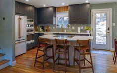 a kitchen with wooden floors and gray cabinets