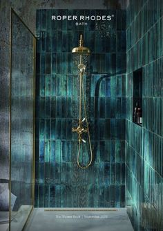 a bathroom with blue tiles and a gold shower head