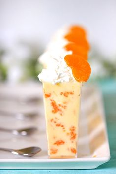 an orange dessert with whipped cream and candies on top is sitting on a plate