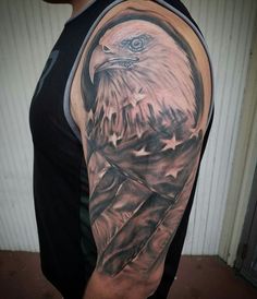 an eagle tattoo on the arm with stars and a flag in the back half sleeve