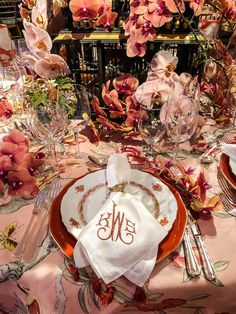 the table is set with pink flowers and place settings for an elegant dinner party or special occasion