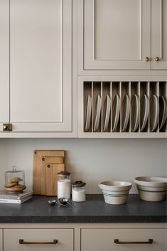 a kitchen counter with plates and bowls on it