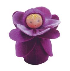 a small doll is sitting on top of a purple flower