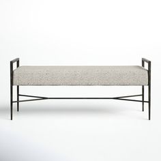 the bench is made from metal and has a white upholstered cushion on it