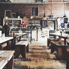 an empty restaurant with wooden tables and benches