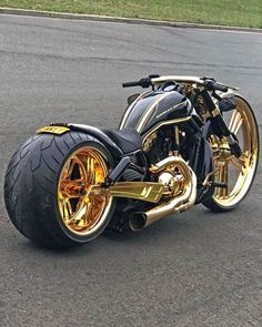 a gold and black motorcycle is parked on the street with it's front tire down