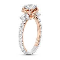 a rose - shaped diamond engagement ring with three stones on the band and an oval center stone