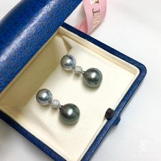 Highline: Famous Style Product Information Origin Tahitian Pearl Jewelry Processed in Japan Material Tahitian Pearl, 18k White Gold and Diamond Dimensions Length 2.8 cm Pearl Shaped: Round Size: 9-10 mm & 11-12 mm Quality: AAAA Nacre: Very Thick Color: Platinum Gary & Black Luster: Very High Accessories Metal: 2.5g of 18k White Gold Other: 0.43ct of SI Quality Natural Diamond Elegant White Gold Tahitian Pearl Earrings, Luxury Tahitian Pearl Earrings In White Gold, Classic Tahitian Pearl Drop Earrings, Luxury Silver Tahitian Pearl Earrings, White Gold Tahitian Pearl Round Earrings, Tahitian Pearls Jewelry, Tahitian Pearl Pendant, Tahitian Pearl Earrings, Pearl Chandelier Earrings