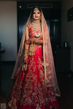 a woman in a red and gold bridal outfit