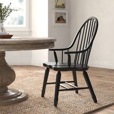 a wooden chair sitting next to a round table