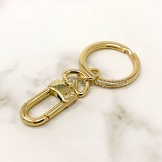 a golden metal keychain on a marble surface