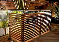 a wooden fence is shown in front of some potted plants on the decking area