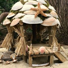 a wooden structure made out of seashells and branches with a starfish on top