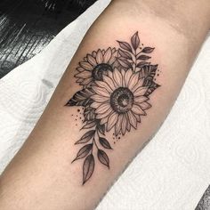 a sunflower tattoo on the left arm