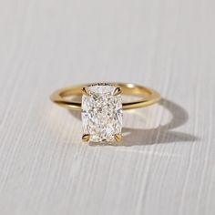 a yellow gold engagement ring with a cushion cut diamond