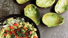 guacamole with tomatoes and spinach in a black bowl