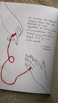 an open book with two hands and a red string