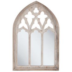 an arched window with white paint on the side and mirrors above it, in front of a white background