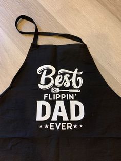 a black apron with the words best flippin'dad ever printed in white on it