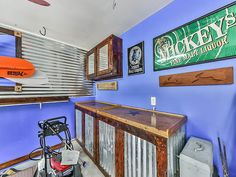 there is a bar in the garage with an orange surfboard on the wall behind it