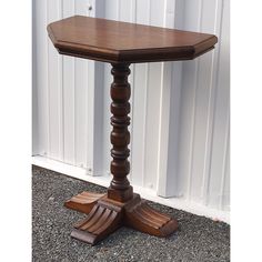 a small wooden table sitting in front of a white wall