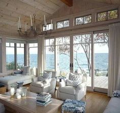 a living room filled with white furniture and lots of windows