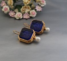 Description Gemstone - Dark Blue Glass Material - Brass Gemstone Size - 18 mm Earring Height Including Hoop - 4 cm Earring Width - 2.3 cm Finish - Smooth and high polished with brilliant shine. Note -The earrings are made to order, production day is about 3-5 working days. The one you receive may be slight different from the one in the picture due to handmade nature, but it will be almost same as in the above picture.These pieces are handcrafted from start to finish and have an imperfect handmade look.These earrings are the perfect addition to your collection. Our rings are meant to be classic enough for everyday wear or to give as a bridesmaid gift. You will receive the same piece as in the picture or identical. Since all gemstones are different from each other, I cannot guarantee that th Nickel-free Blue Pearl Earrings Gift, Blue Gemstone Earrings For Formal Occasions, Nickel-free Blue Crystal Earrings For Formal Occasions, Classic Blue Pearl Drop Earrings, Classic Blue Earrings As Gift, Blue Gemstone Pearl Drop Earrings, Classic Blue Pearl Earrings For Gift, Blue Round Clip-on Jewelry, Blue Clip-on Earrings For Gift