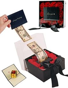 a person is opening a gift box with money and red roses in it, which are tied to a black ribbon