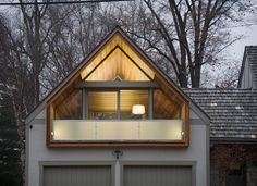 two garages with lights on in front of trees