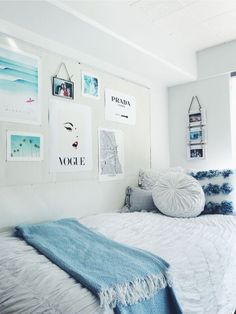 a bedroom with white walls and pictures on the wall